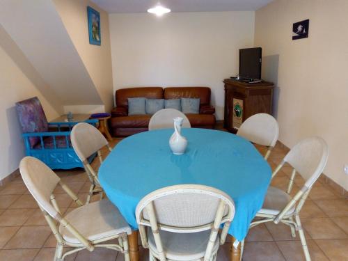 une salle à manger avec une table et des chaises bleues dans l'établissement Gîte Etxe Xuri, à Ossès