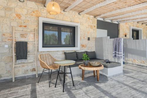 a patio with a table and chairs and a couch at "Four Olives" Luxury Rooms, Afitos #FeelsLikeHome in Afitos