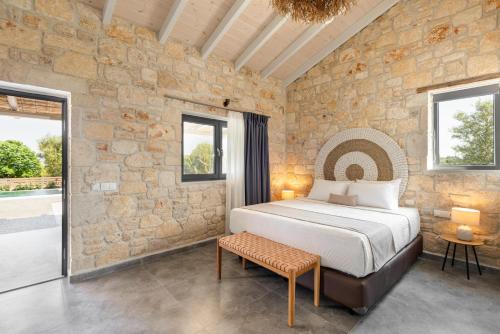 - une chambre avec un lit et un mur en pierre dans l'établissement #FLH - "Four Olives" Luxury Rooms, à Afytos