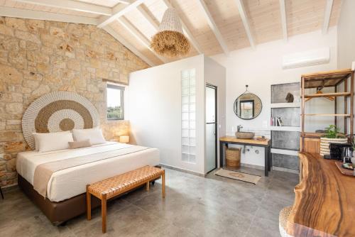 a bedroom with a bed and a stone wall at "Four Olives" Luxury Rooms, Afitos #FeelsLikeHome in Afitos