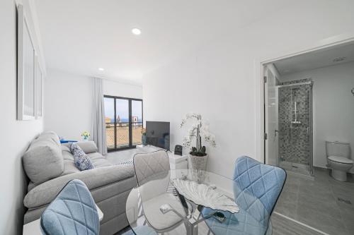 a living room with a couch and a table and chairs at Santa Luzia I by An Island Apart in Funchal