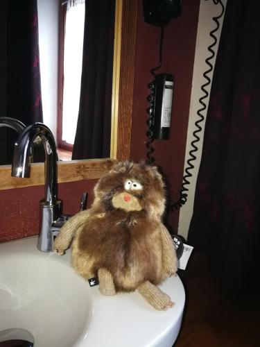 a stuffed monkey sitting on top of a bathroom sink at Hotel Ehrwalderhof in Ehrwald
