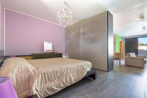 una camera con un grande letto e un lampadario a braccio di The Loft Suite by BarbarHouse a Ostuni