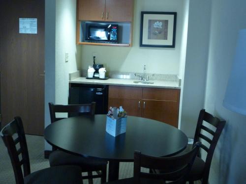 a kitchen with a table with chairs and a sink at Wingate by Wyndham Erlanger - Florence - Cincinnati South in Erlanger