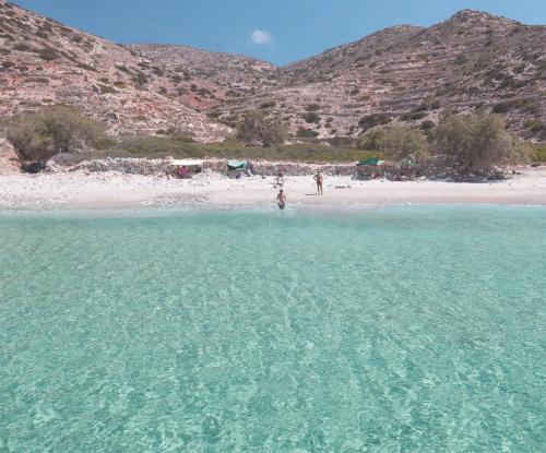 a person standing in the water at a beach at Dimitrakis Guesthouse in Donoussa