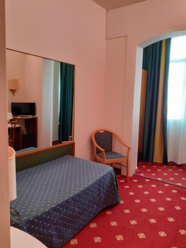 een hotelkamer met een bed en een stoel bij Polo Hotel in Usmate Velate