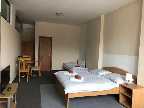 - une chambre avec un lit, une table et des chaises dans l'établissement Šport Hotel Bôrik, à Žilina