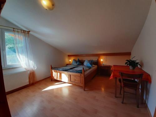 1 dormitorio con cama, mesa y ventana en Weingut Ringwald, en Herbolzheim