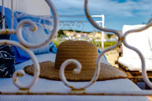 a straw hat sitting on top of a bed at Monte da Lagoa in Altura