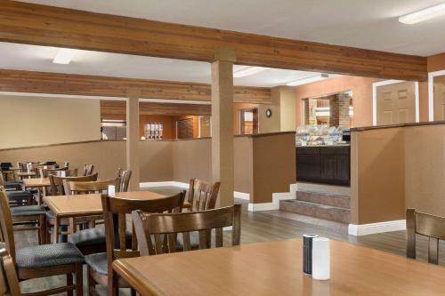 a restaurant with tables and chairs and a bar at Baymont by Wyndham Cortez in Cortez