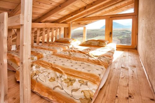two beds in a wooden room with a large window at Accommodation "MONTELAGO"- Virpazar,Skadar Lake in Virpazar