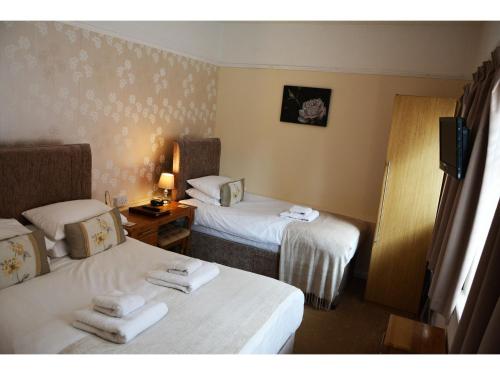 a hotel room with two beds and a television at Ashlea Guest House in Banbury