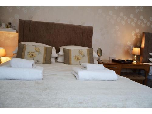 a large white bed with two pillows on it at Ashlea Guest House in Banbury
