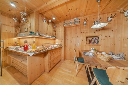 een keuken met houten wanden en een tafel en stoelen bij Garni Tramans in Selva di Val Gardena