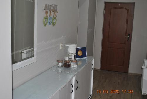 La salle de bains est pourvue d'un comptoir et d'une cafetière. dans l'établissement Pokoje z łazienkami, à Kołobrzeg