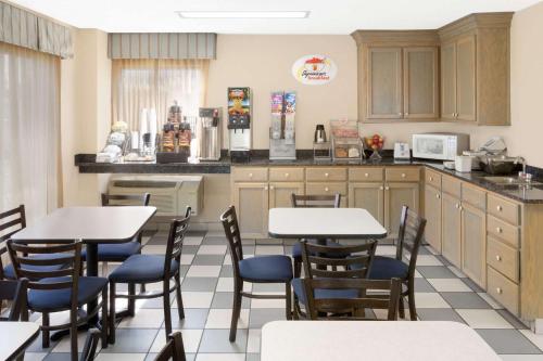 een restaurant met tafels en stoelen in een keuken bij Super 8 by Wyndham Hattiesburg South in Hattiesburg