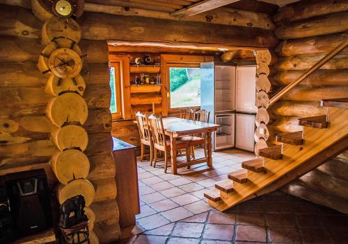 a kitchen and dining room in a log cabin at Viesu māja ar saunu "Lankalni" in Dzelda