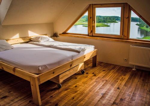 a bed in a room with a large window at Viesu māja ar saunu "Lankalni" in Dzelda