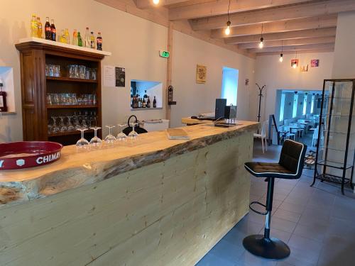 - un bar avec un comptoir en bois et une chaise dans l'établissement Auberge de Thelis, à Thélis-la-Combe