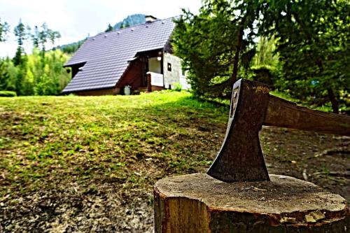 a statue of a wooden object in front of a house at Chata Bačova skala in Liptovský Ján