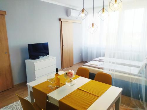 a room with a dining table and a bed at Lora Apartman in Nyíregyháza