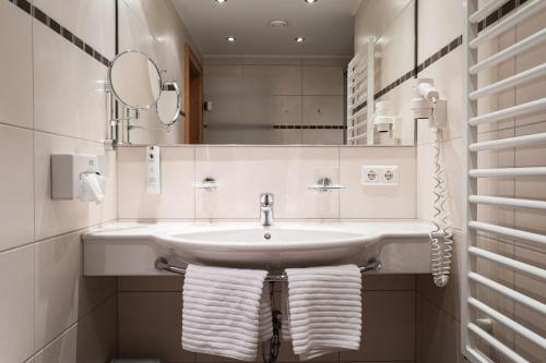 a bathroom with a sink and a mirror and towels at Gästehaus Stotter in Neukirchen am Großvenediger