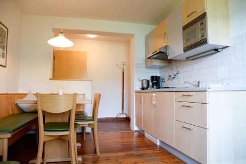 a kitchen with a table and a dining room at Appartements Kirchtalhof in Lana