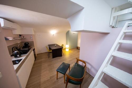 a kitchen and a living room with a ladder and chairs at Liconti Exclusive Rooms in Pulsano