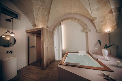 a bathroom with a tub with a stone ceiling at Liconti Exclusive Rooms in Pulsano