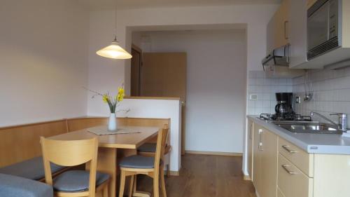 a small kitchen with a table and chairs in a kitchen at Appartements Kirchtalhof in Lana