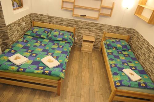 two twin beds in a room with wooden floors at Apartamenty u Łukasza in Zakopane
