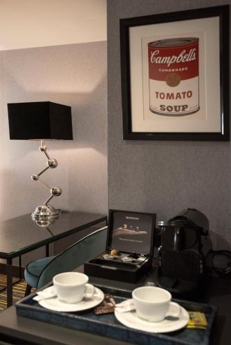 a table with two cups and a laptop on it at President Hotel Athens in Athens