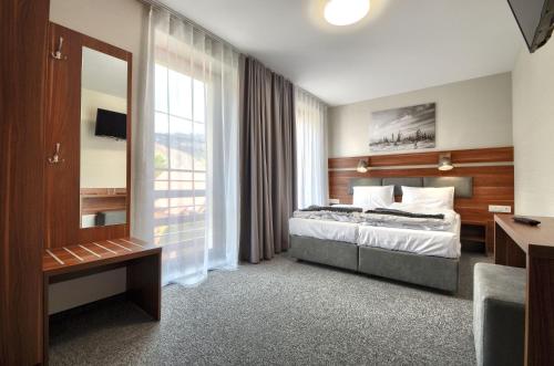 a hotel room with a bed and a window at Gucio - pokoje z restauracją Szczyrk in Szczyrk