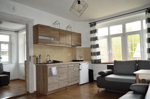 a kitchen with a couch and a table in a room at Apartament z widokiem na Śnieżkę in Karpacz