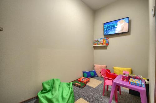 a room with chairs and a table and a tv at Gucio - pokoje z restauracją Szczyrk in Szczyrk