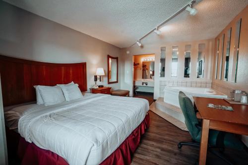 1 dormitorio con cama, escritorio y lavamanos en Lamplighter Inn and Suites - North, en Springfield