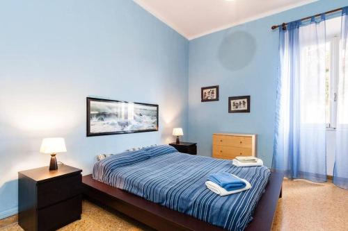 Un dormitorio azul con una cama y una ventana. en A Due Passi Dal Treno, en Pisa