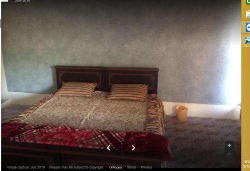 Bahar E Madina Mansehra في Chitta Batta: غرفة نوم بسرير كبير ومخدات حمراء
