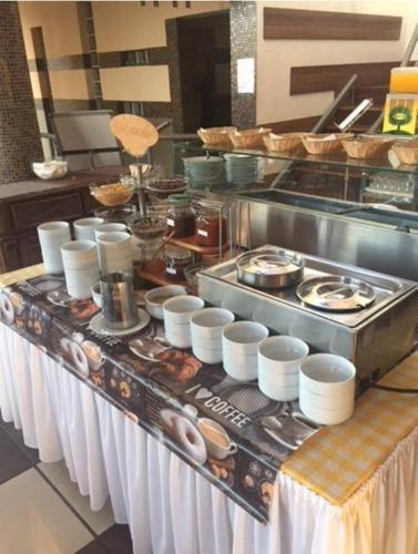 a buffet line in a kitchen with food on it at Piknik Wellness Hotel in Siófok
