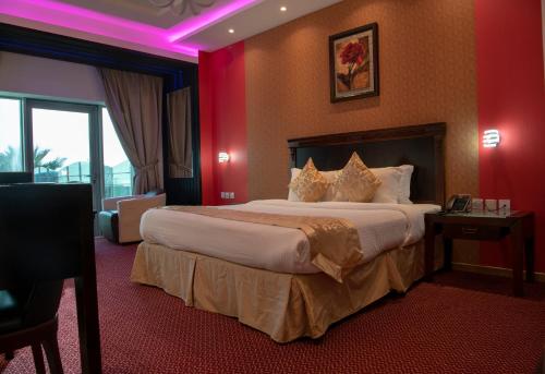 a hotel room with a large bed with pink lighting at Jazan Inn Hotel in Jazan