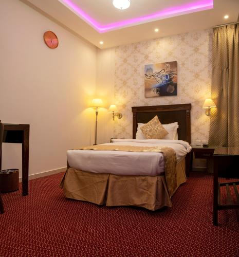 a bedroom with a large bed with a purple lighting at Jazan Inn Hotel in Jazan