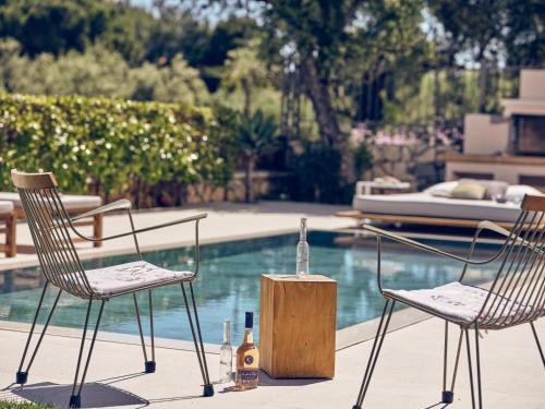 two chairs and a table with bottles of wine at Cielo villas - An Authentic Mediterranean Living in Zakynthos Town
