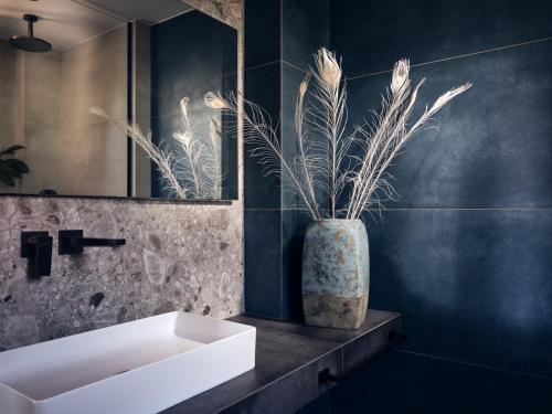 a bathroom with a sink and a vase with a plant at Cielo villas - An Authentic Mediterranean Living in Zakynthos Town