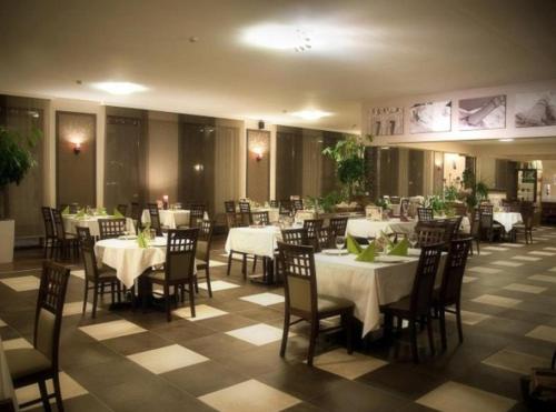 a dining room with white tables and chairs at Piknik Wellness Hotel in Siófok