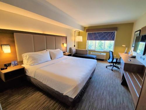 a hotel room with a large bed and a desk at Holiday Inn Express Hotel & Suites Seattle North - Lynnwood by IHG in Lynnwood