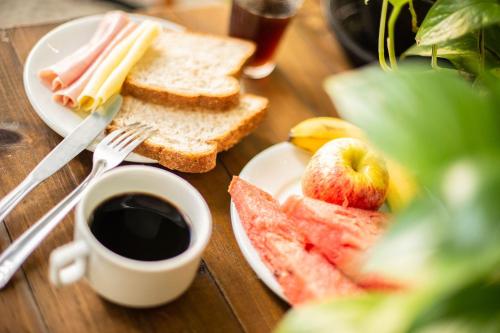 uma mesa com um prato de sanduíches e uma chávena de café em Che Lagarto Hostel Ipanema no Rio de Janeiro