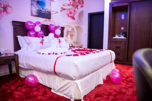 a bedroom with a large bed with pink balloons on it at Jazan Inn Hotel in Jazan