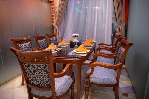 a dining room table and chairs with orange napkins at Jazan Inn Hotel in Jazan