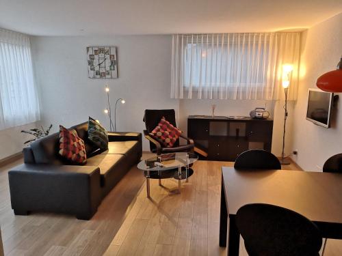 ein Wohnzimmer mit einem Sofa, Stühlen und einem Tisch in der Unterkunft Apartment Gornerhaus in Grindelwald