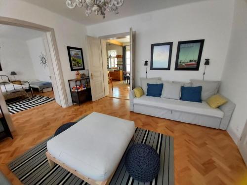 a living room with a white couch and blue pillows at Belvárosi Kertesház in Keszthely